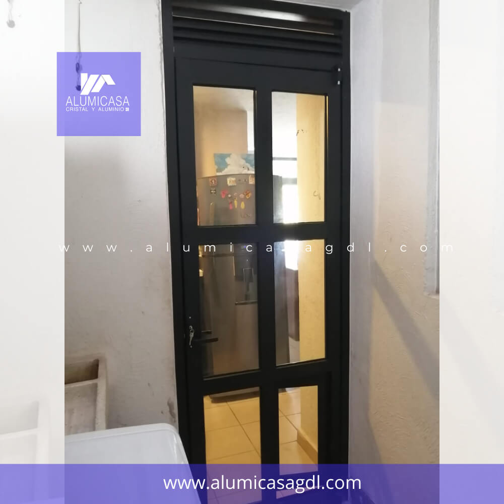 Puerta de aluminio con respiradero superior aluminio negro, divisiones cuadricula vidrio transparente