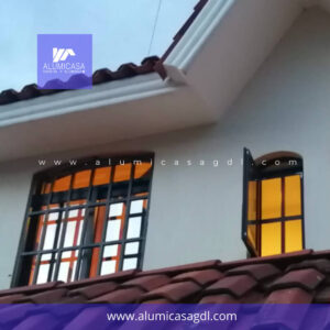 Ventana de aluminio color negro cubierta vidrio con control solar, protección de herrería cuadriculada