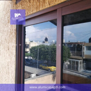 Ventana de aluminio corrediza tono madera cubierta cristal filtrasol
