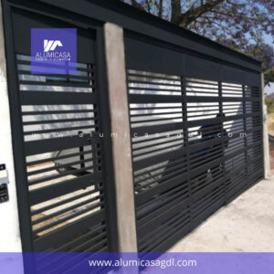 Porton plegadizo con montaje de viga superior y puerta peatonal con jaladera de acero inoxidable color negro
